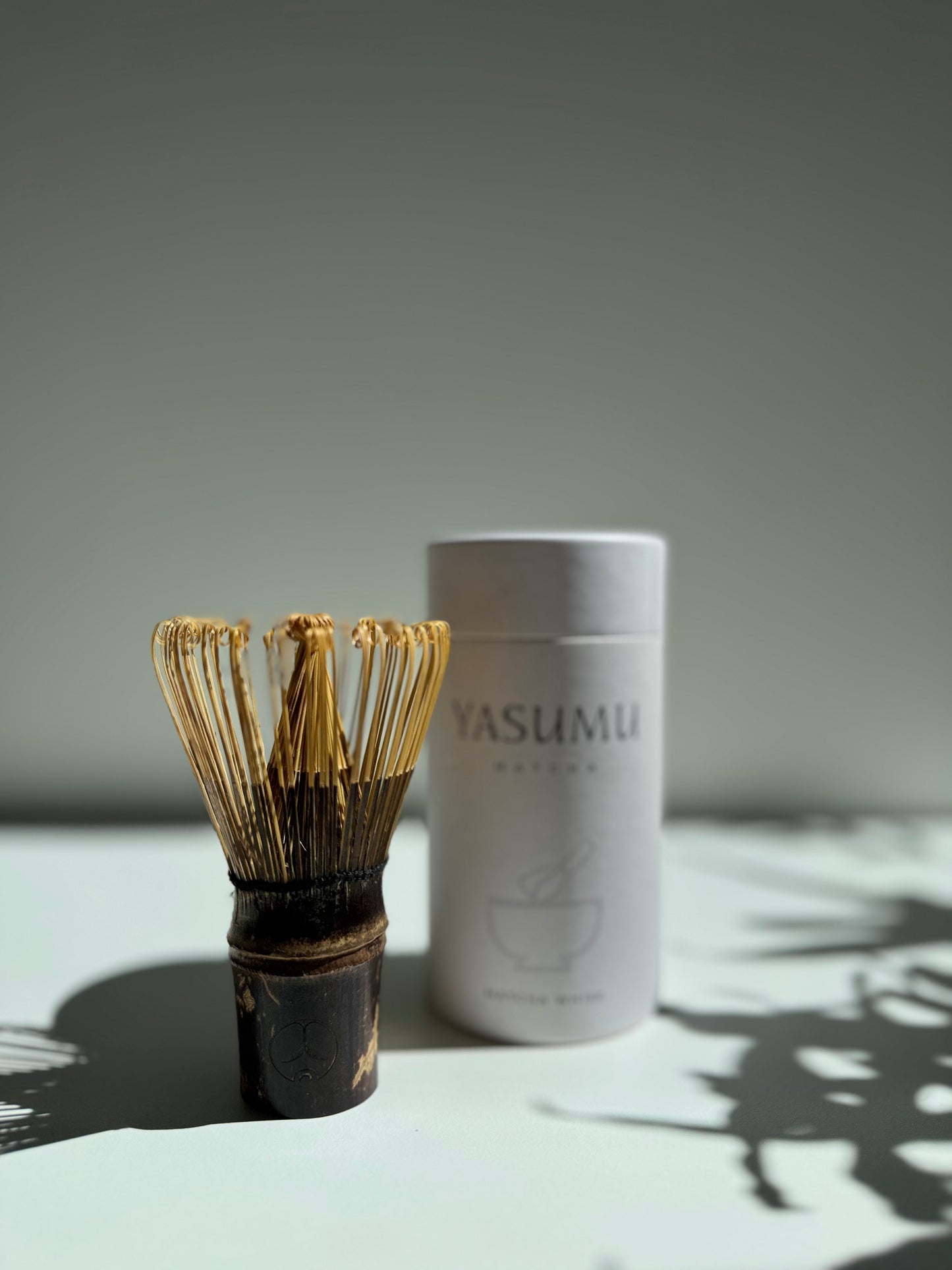 Handcrafted bamboo matcha whisk (chasen) by Yasumu, shown with premium cylindrical box