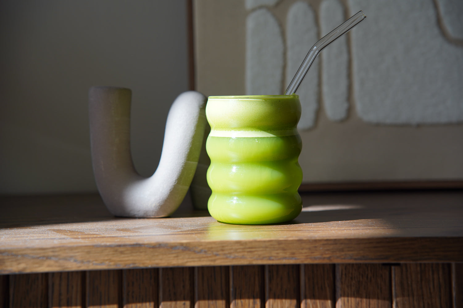 Creamy ceremonial matcha latte in green wavy glass with glass straw – Yasumu Matcha