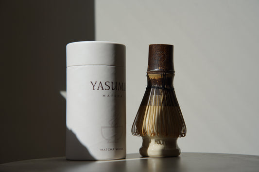 Handcrafted bamboo matcha whisk (chasen) by Yasumu, shown with premium cylindrical box